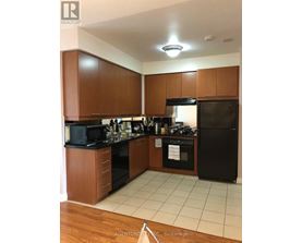 A kitchen with wooden cabinets and black appliances.