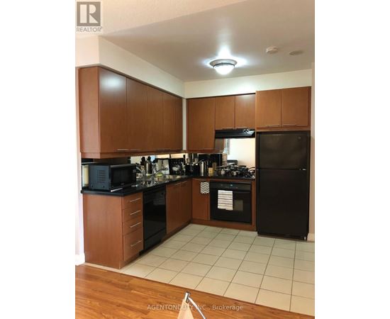A kitchen with wooden cabinets and black appliances.
