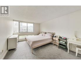 A bedroom with a bed, desk, and chair.