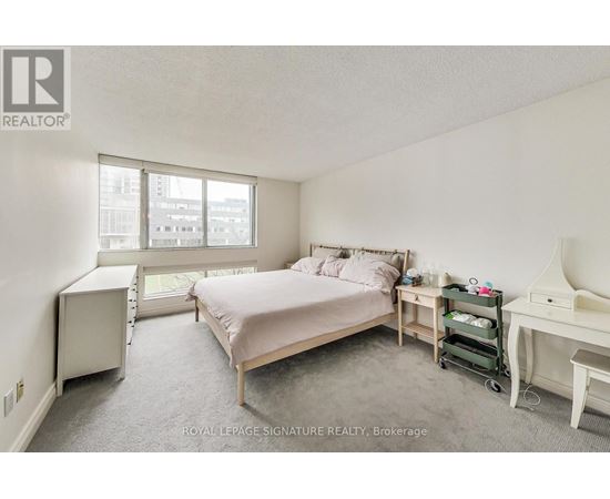 A bedroom with a bed, desk, and chair.