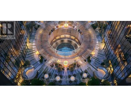 A modern building with a circular atrium and a pool in the middle.