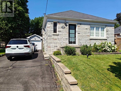 A white car is parked in front of a house with a sign that says "REALTOR".