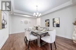 A dining room with a table set for two and a chandelier hanging from the ceiling.