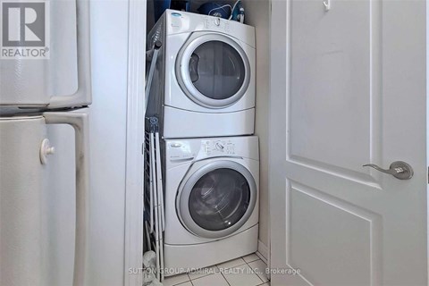 A white washing machine is stacked on top of another in a small space.