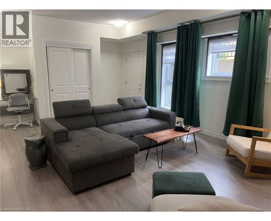 A grey sofa in a living room with a wooden coffee table.