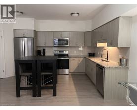 A kitchen with a black table and chairs.