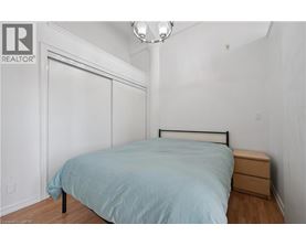 A bedroom with a bed, nightstand, and a lamp.