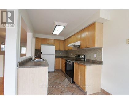 A kitchen with wooden cabinets and a white fridge.