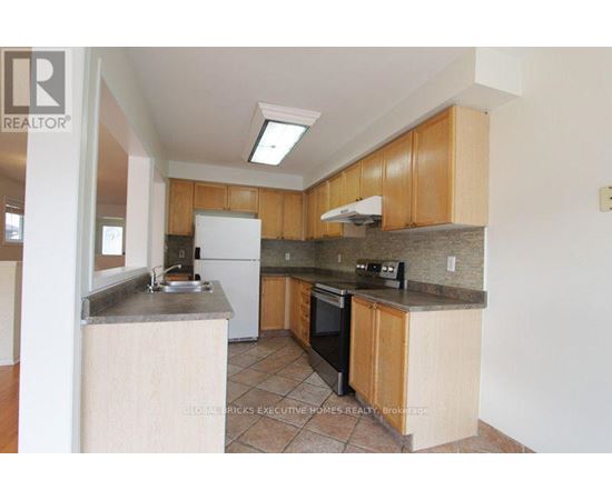 A kitchen with wooden cabinets and a white fridge.