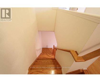 A wooden staircase with a white wall on the side.