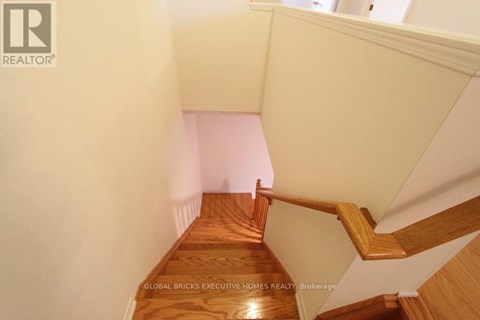 A wooden staircase with a white wall on the side.