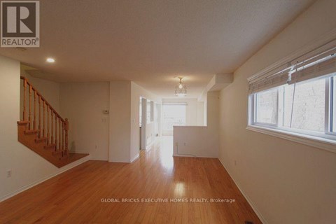A spacious room with wooden floors and white walls.