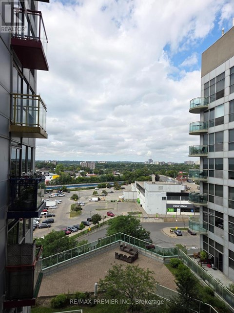A view from a high-rise building looking down at a parking lot and other buildings.