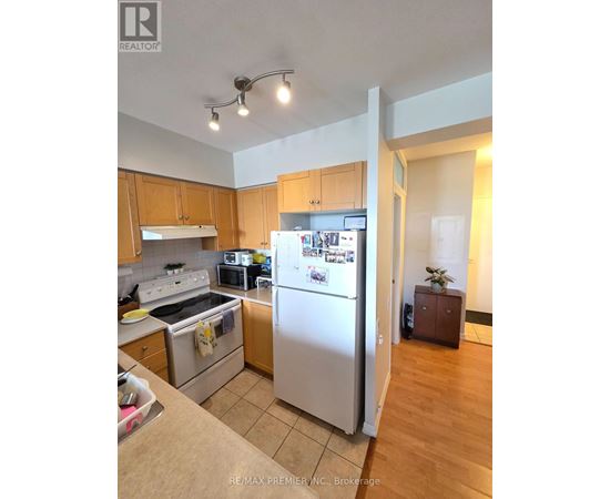 A kitchen with a refrigerator, oven, and microwave.