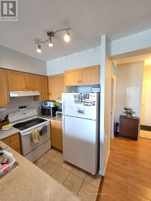 A kitchen with a refrigerator, oven, and microwave.