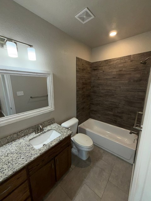A bathroom with a sink, toilet, and bathtub.