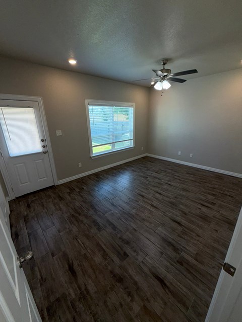 A room with a ceiling fan and a window.