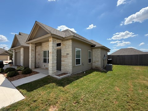A house with a brown roof and a grey stone exterior.