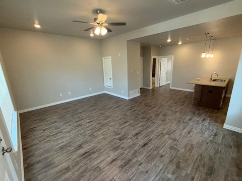 A room with wood flooring and a ceiling fan.