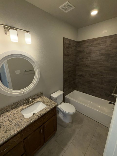A bathroom with a sink, toilet, and bathtub.