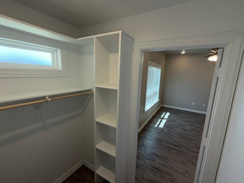 A room with a window and a shelf.