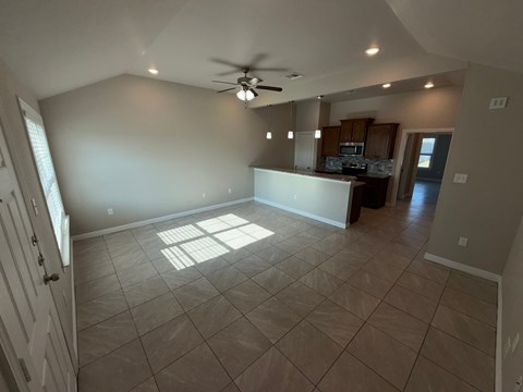 A room with a ceiling fan and tiled flooring.