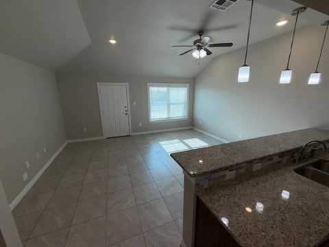 A kitchen with a counter and a fan.