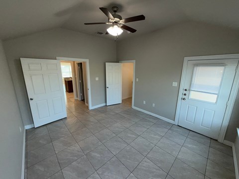 A room with a ceiling fan and tile flooring.