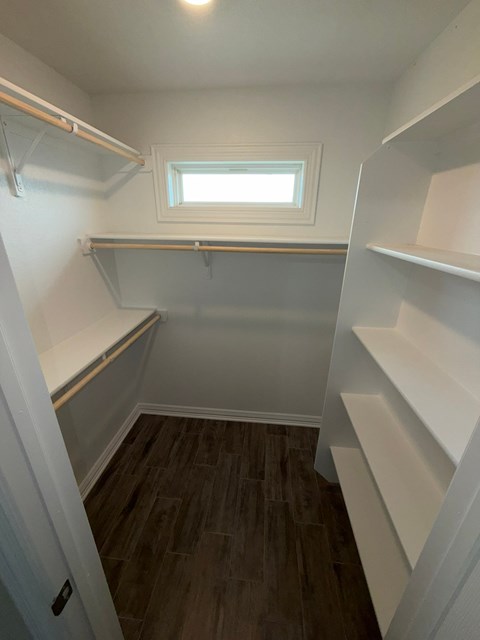 A small, empty room with a window and shelving.