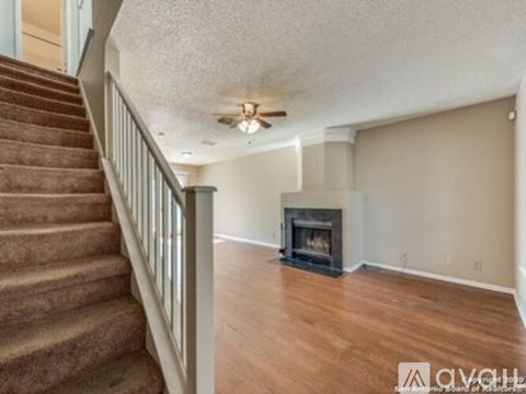 A living room with a fireplace and a staircase.
