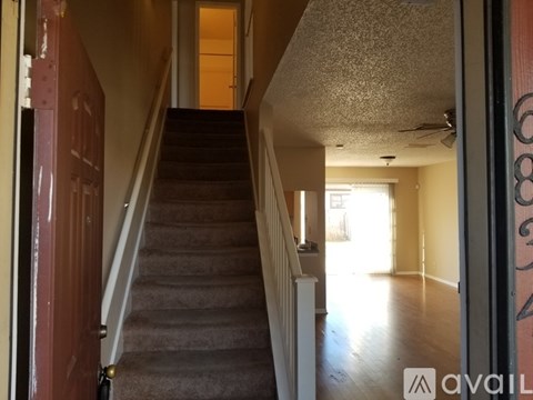 A staircase with a carpeted runner and a white handrail.