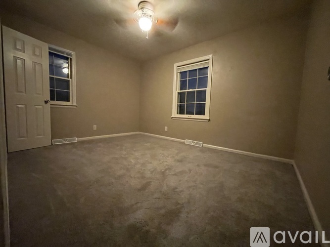 A room with a door, window, and a light on.