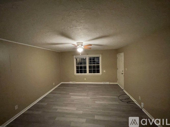 A room with a ceiling fan and a window.