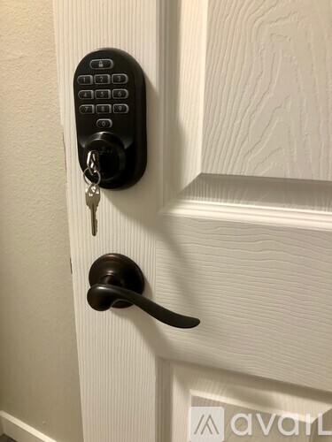 A door handle with a keypad and a key.