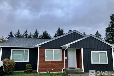 A house with a black exterior and a white door is shown.