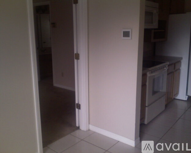 A kitchen with a white refrigerator and a white door.
