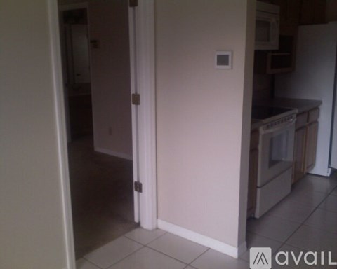 A kitchen with a white refrigerator and a white door.