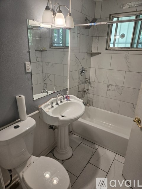 A bathroom with a toilet, sink, and bathtub.