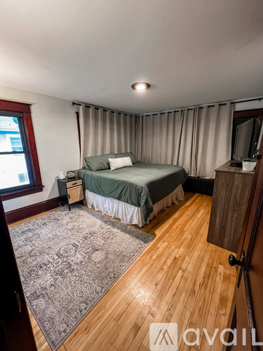 A bedroom with a bed, nightstand, and television.