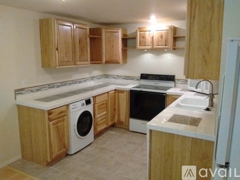 A kitchen with wooden cabinets and a white dishwasher.