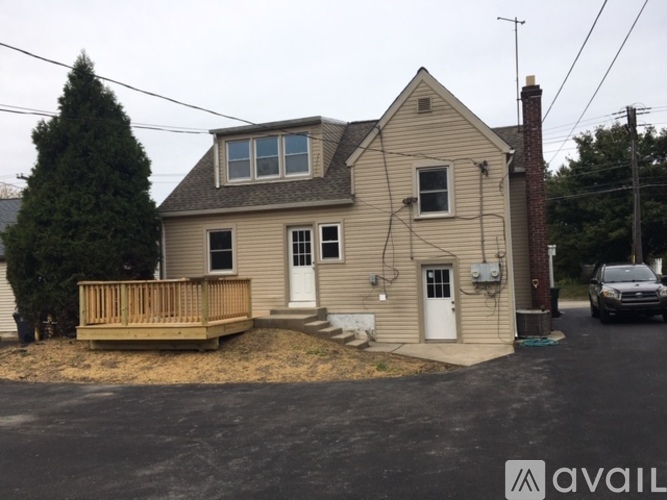 A house with a white door and a brown deck.
