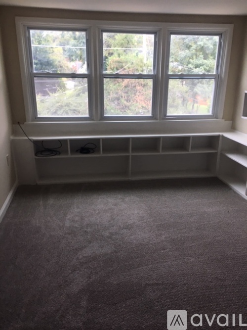 A room with a large window and a carpeted floor.