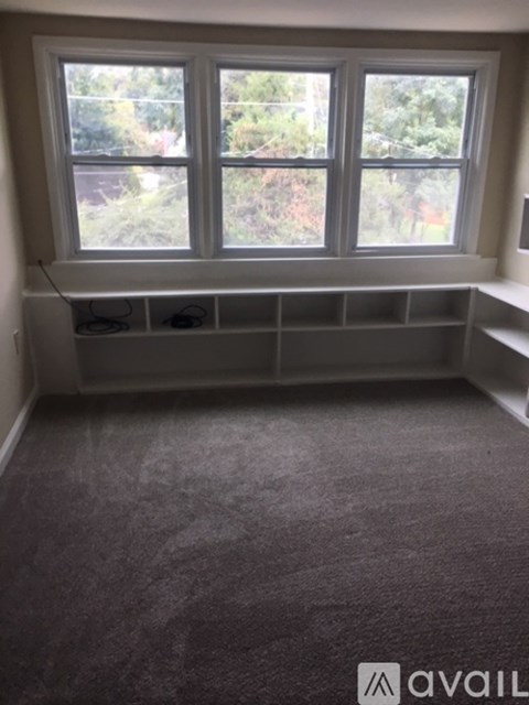 A room with a large window and a carpeted floor.