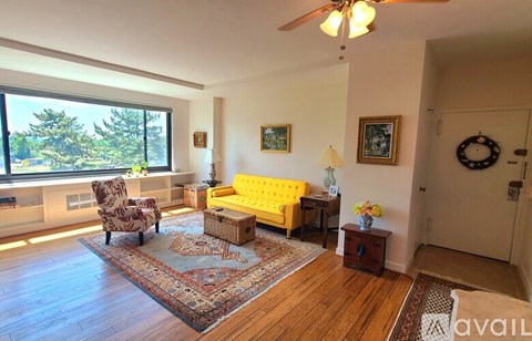 A living room with a yellow couch and a rug.