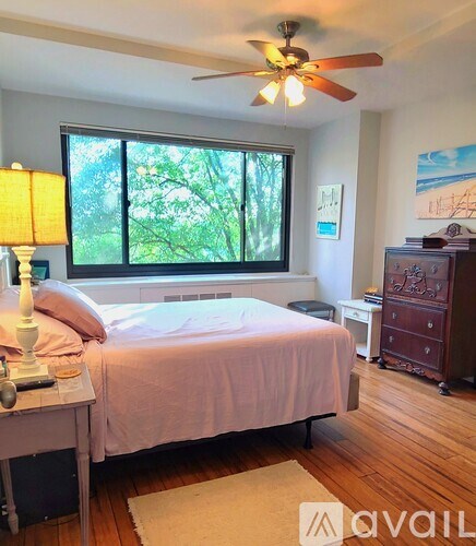 A bedroom with a bed, a dresser, and a ceiling fan.