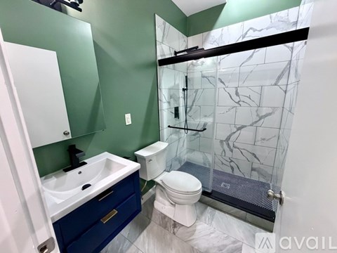 A bathroom with a green wall and a white toilet.