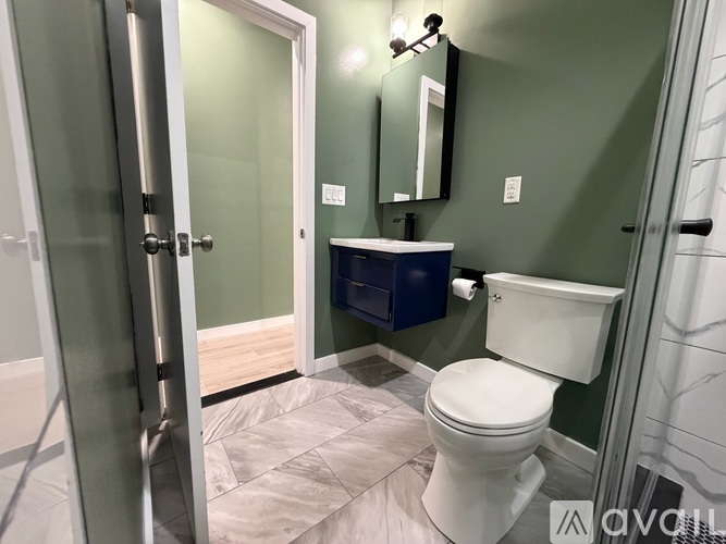 A white toilet in a bathroom with green walls.