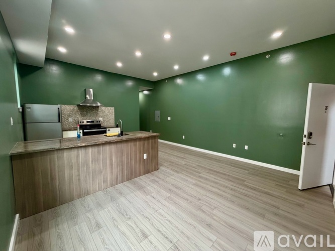 A kitchen area with a counter and a refrigerator.