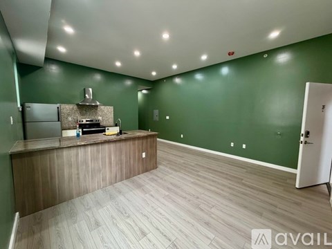 A kitchen area with a counter and a refrigerator.
