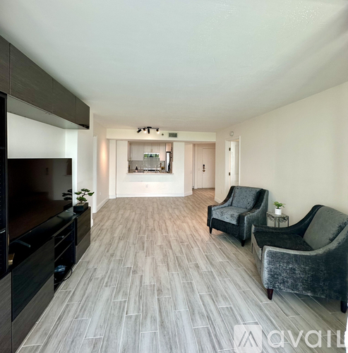 A spacious room with grey chairs and a wooden floor.